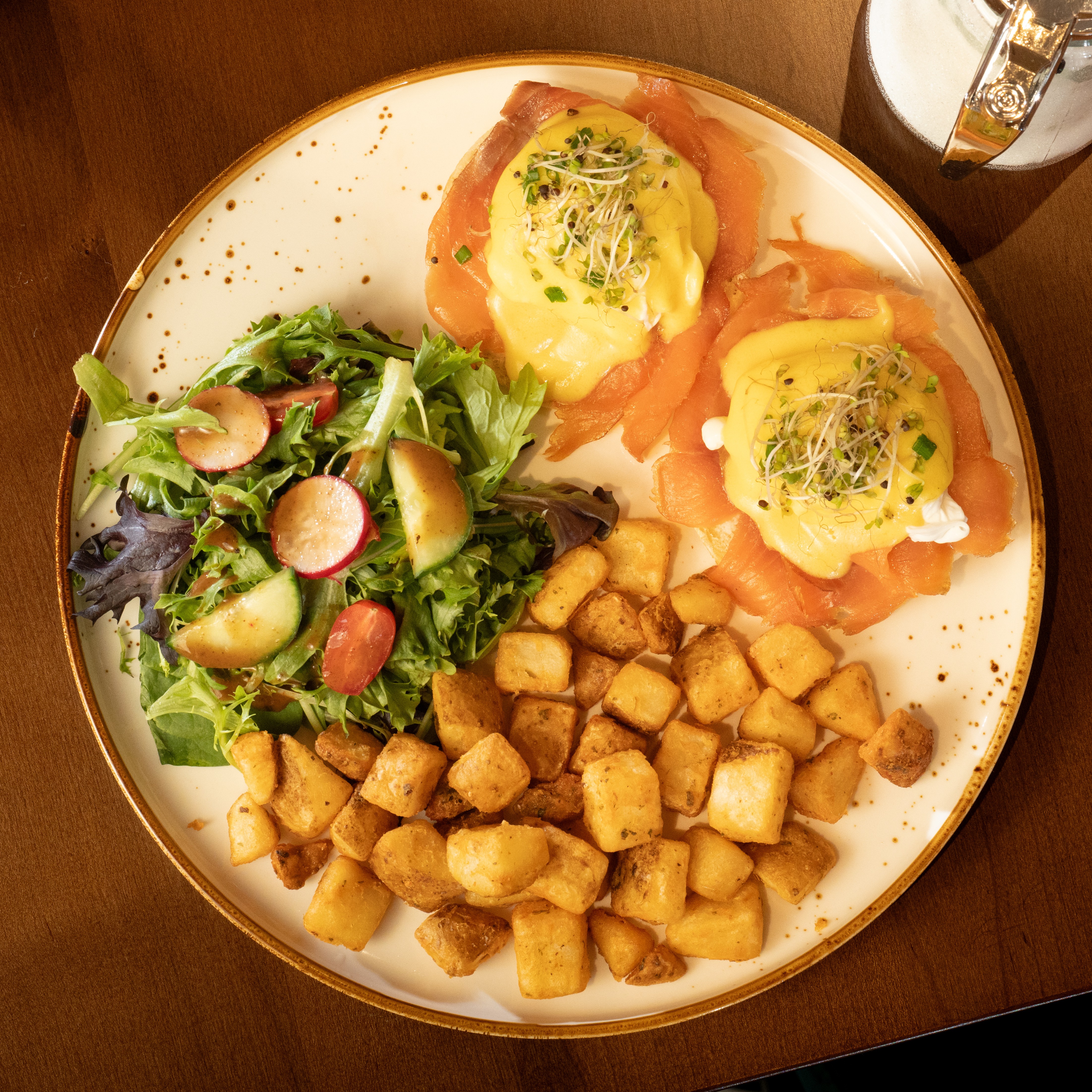 West Coast Salmon Benny — Smoked salmon, two poached eggs and hollandaise on an English muffin with home fries and house salad. — Benedicts at SOLENA Brunch & Bar in Corso Italia, Toronto