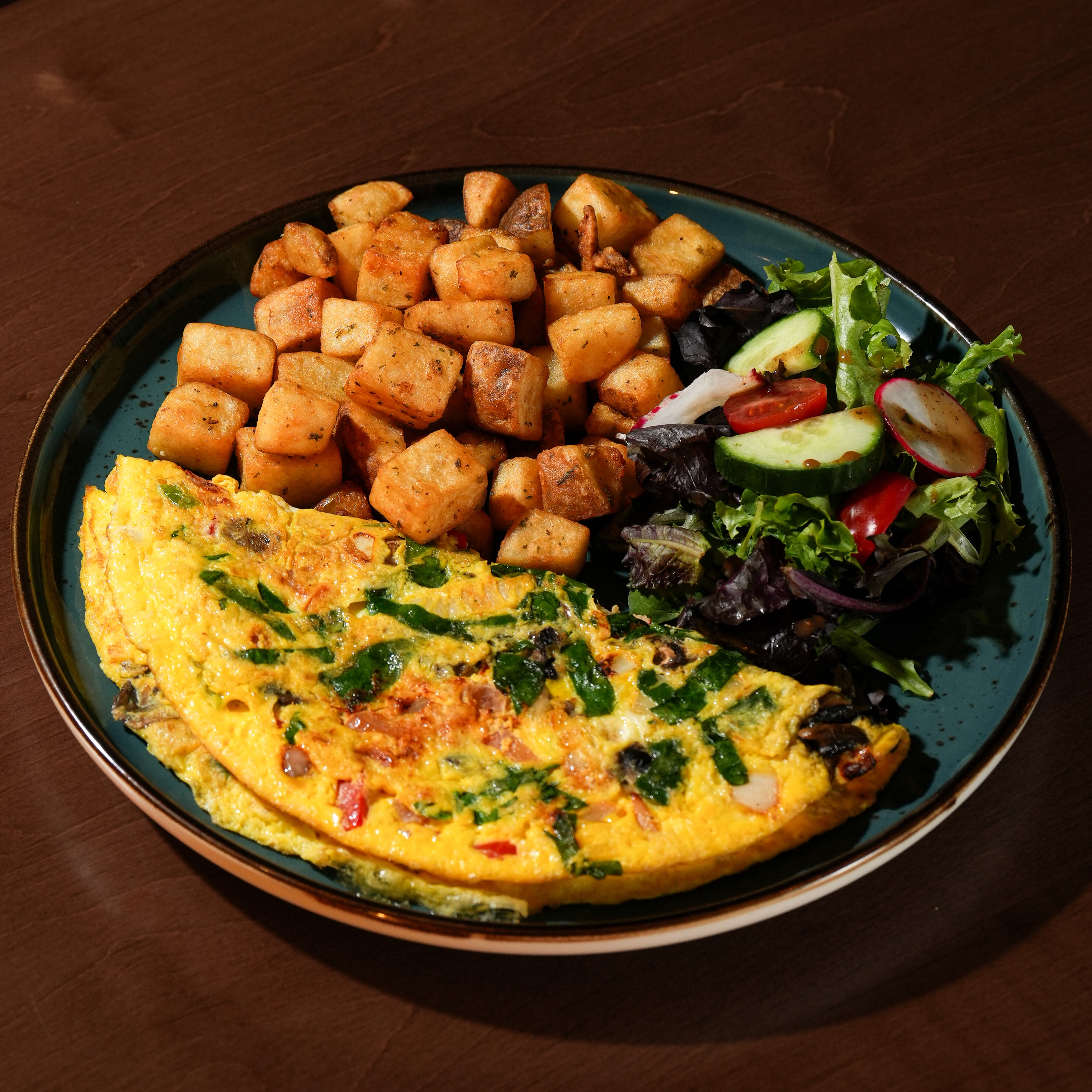 Garden Omelette — Tomatoes, mushrooms, peppers, onions and spinach. Served with herbed home fries, house salad, and choice of toast.
