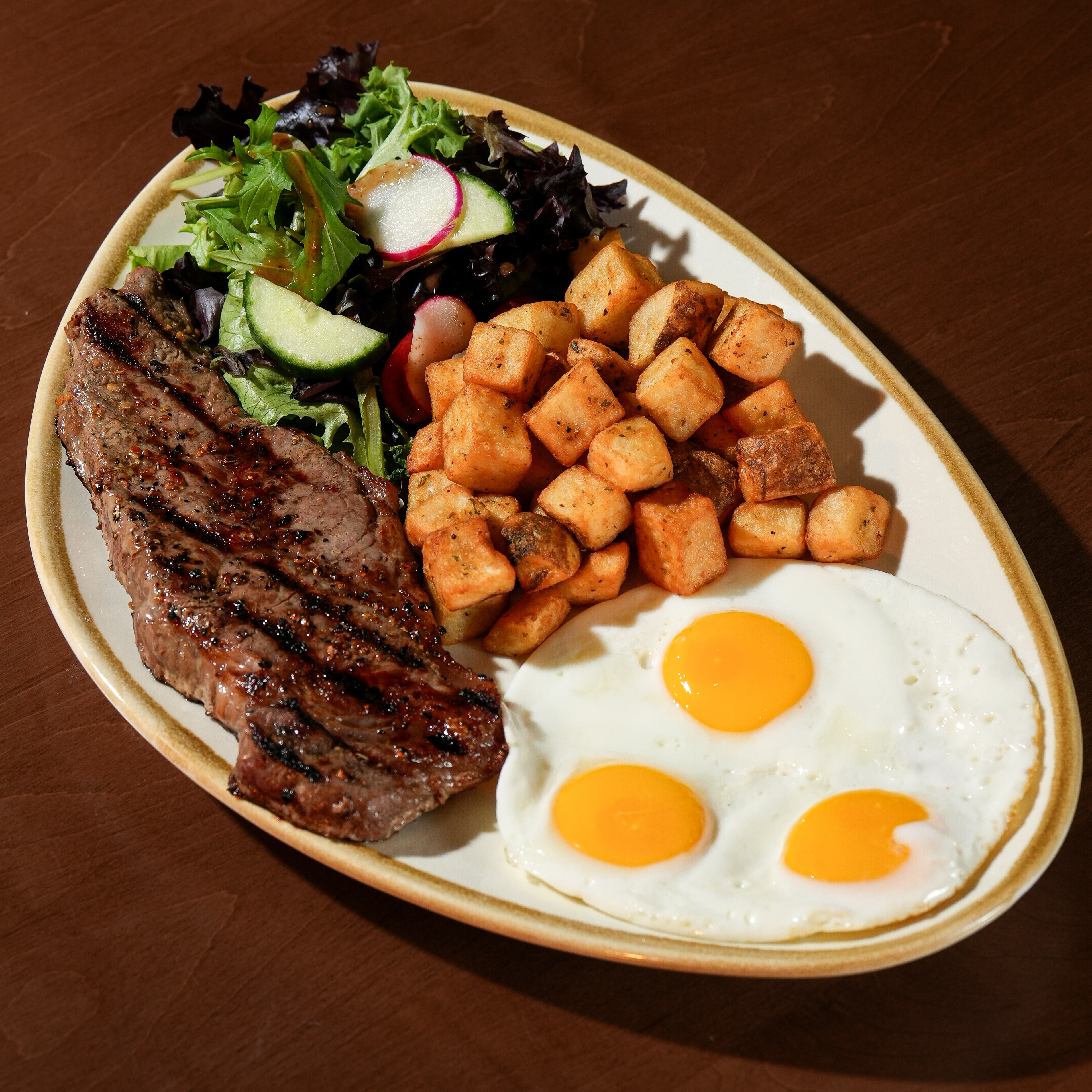 Steak & Eggs — 8 oz AAA striploin steak with eggs your way, herbed home fries, house salad, and toast. — Brunch Favourites at SOLENA Brunch & Bar in Corso Italia, Toronto