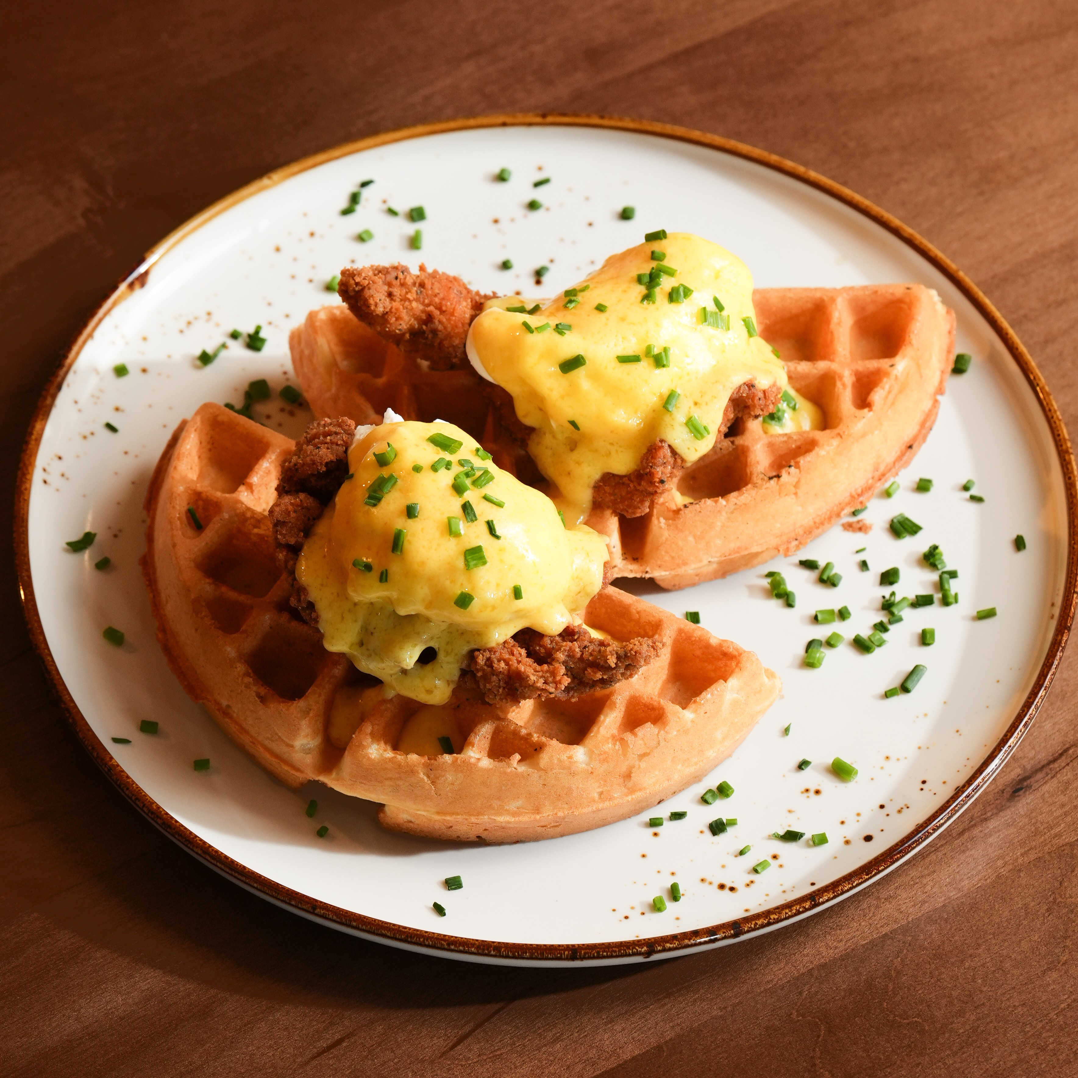 Southern Chicken & Waffle Benny — Golden Belgian waffle with crispy fried chicken, poached eggs and hollandaise. — Benedicts at SOLENA Brunch & Bar in Corso Italia, Toronto