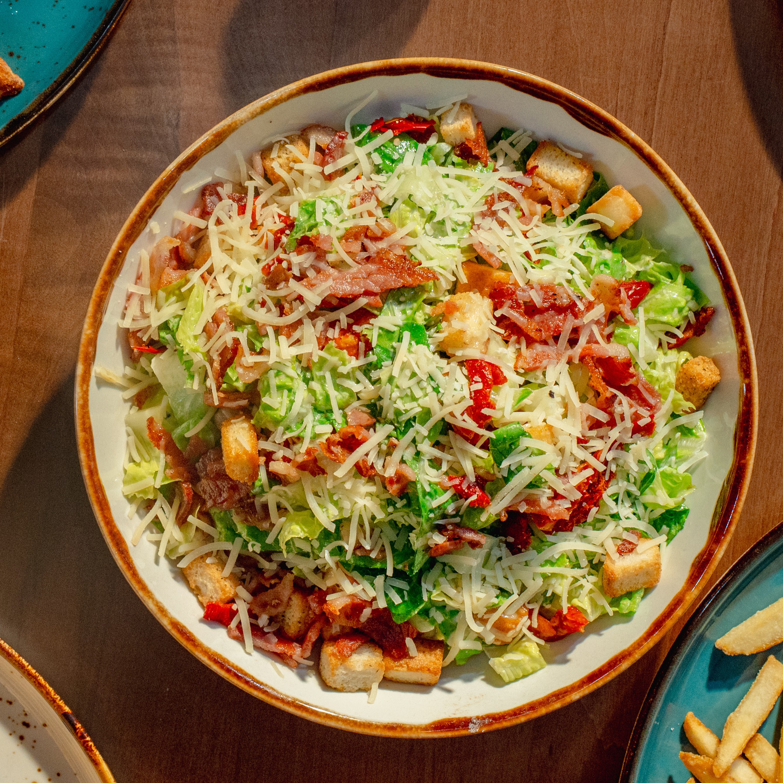 Solena Caesar Salad — Romaine, bacon, croutons, parmesan, sun-dried tomatoes, and Caesar dressing. — Salads at SOLENA Brunch & Bar in Corso Italia, Toronto